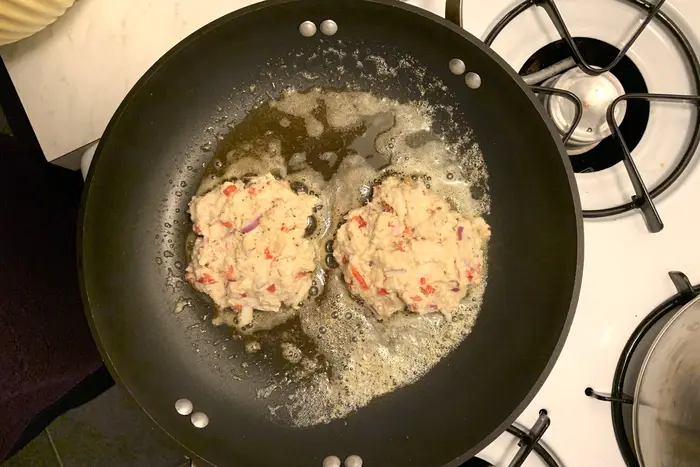 Crab cakes sizzling in butter